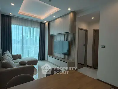 Modern living room with elegant furniture and large windows offering city views.