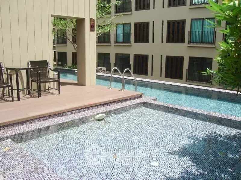 Luxurious apartment complex with stunning poolside view and modern architecture.
