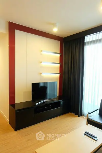 Modern living room with sleek TV stand and floor-to-ceiling windows for natural light.