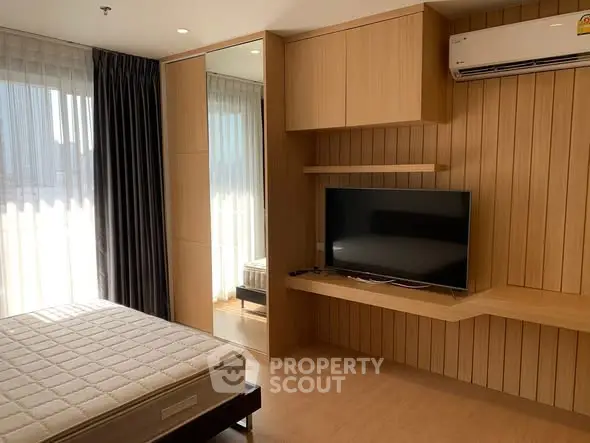 Modern bedroom with wooden paneling and built-in TV unit