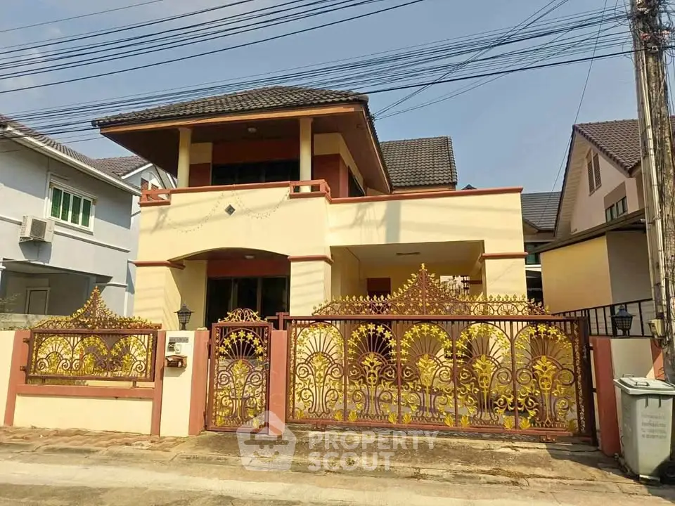 Charming two-story house with ornate golden gate and spacious driveway in a serene neighborhood.