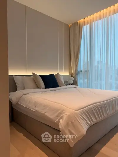 Luxurious bedroom with modern design and city view, featuring elegant lighting and plush bedding.