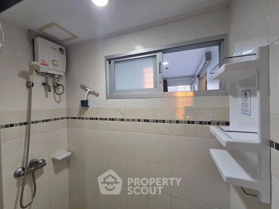 Modern bathroom with shower and water heater in a tiled interior