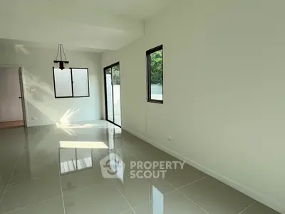 Spacious modern living room with large windows and glossy tiled floors