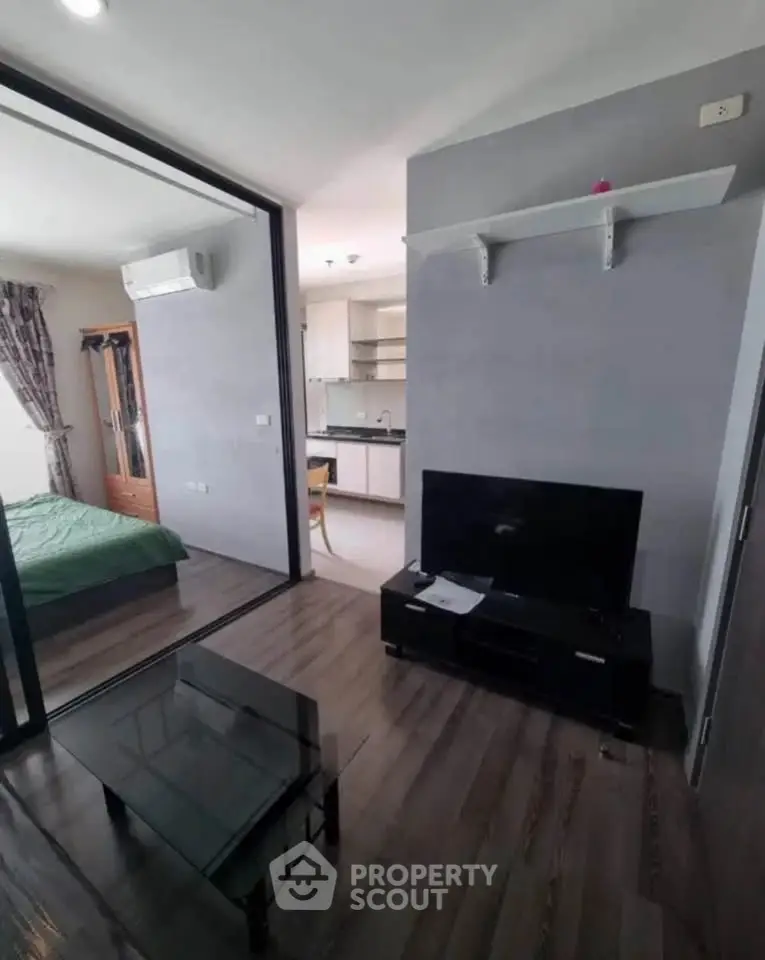 Modern apartment interior with glass partition, cozy living area, and stylish kitchen.