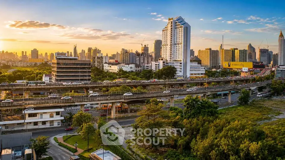 Stunning cityscape view with modern high-rise buildings and lush greenery at sunset.