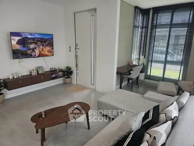 Modern living room with sleek furniture and large windows offering natural light.