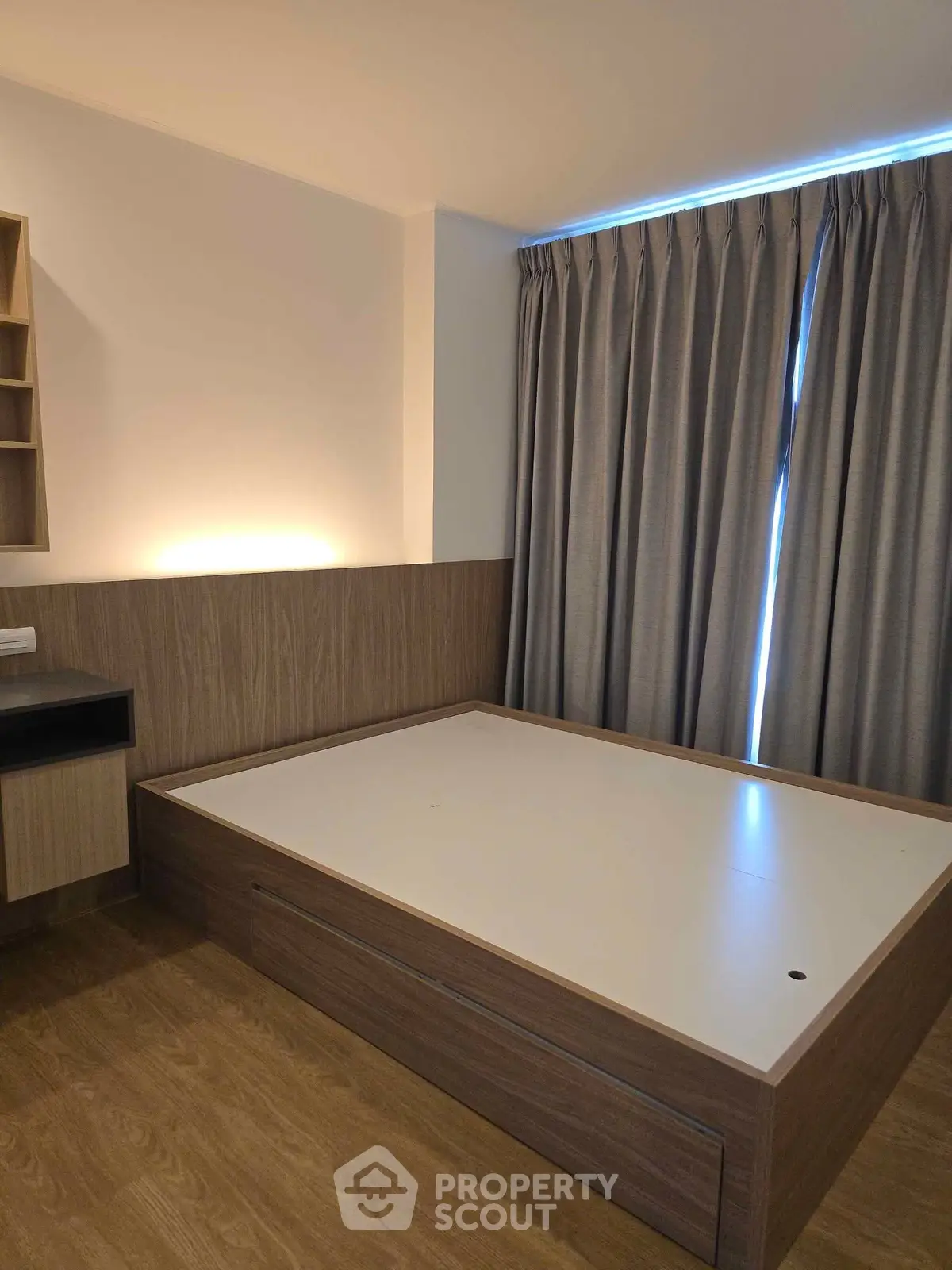Modern bedroom with sleek wooden furniture and elegant curtains