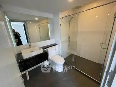 Modern bathroom with glass shower and sleek black countertop