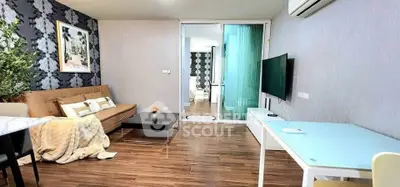 Modern living room with stylish decor and open layout, featuring a cozy sofa and sleek TV setup.