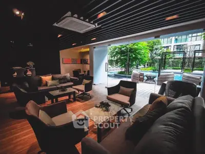 Luxurious living room with modern furniture and poolside view, perfect for relaxation.