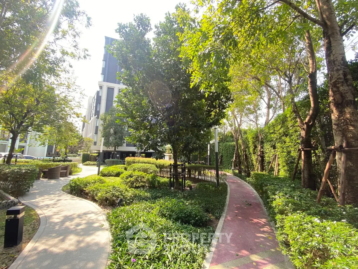 Lush garden path in modern residential complex with vibrant greenery and serene atmosphere.