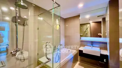 Modern bathroom with glass shower and bathtub in luxury apartment