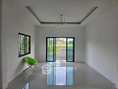 Spacious modern living room with large windows and balcony access