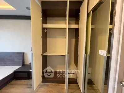 Spacious bedroom with modern wardrobe and wooden flooring in a stylish apartment.