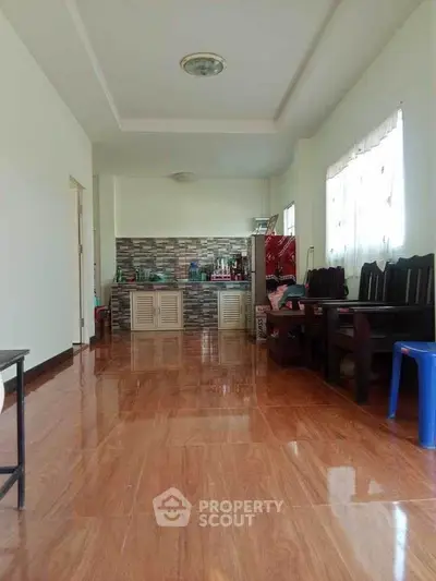 Spacious living area with wooden flooring and open kitchen layout