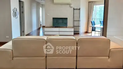 Spacious living room with modern decor and balcony view in a luxury apartment.