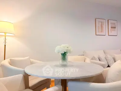 Elegant living room with white decor and round marble table, perfect for modern living.