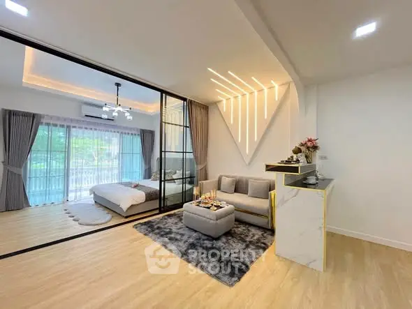 Modern open-plan living room with stylish decor and bedroom view