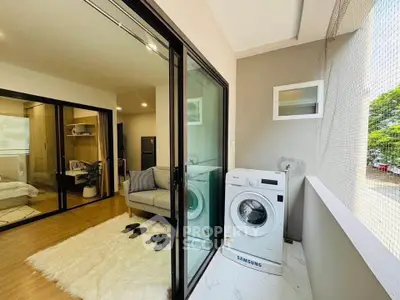 Modern apartment with balcony featuring washing machine and cozy interior view.
