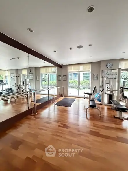 Spacious gym with modern equipment and large mirrors in a well-lit area.