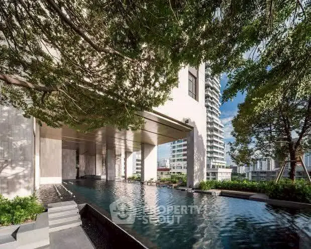 Luxurious residential building with serene pool and lush greenery, offering a tranquil urban oasis.