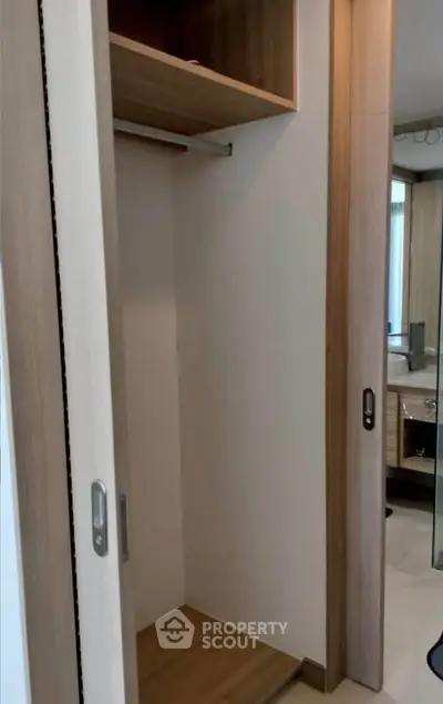 Spacious wooden closet with sliding doors in modern interior design.