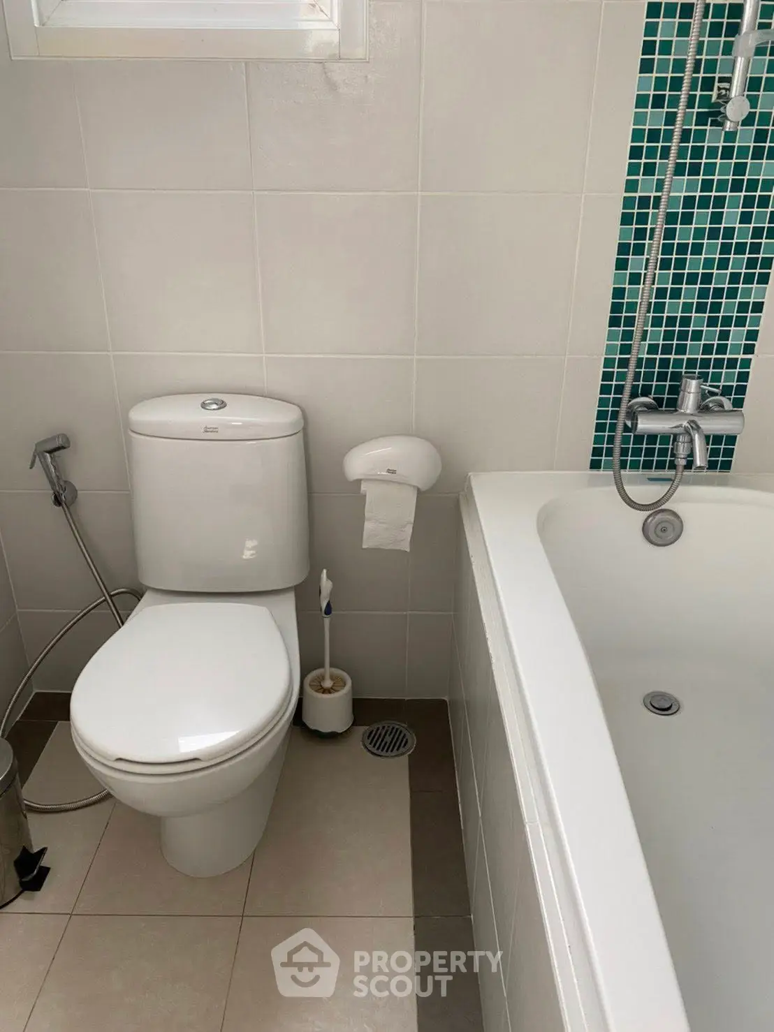 Modern bathroom with white fixtures and a bathtub, featuring sleek tile design.