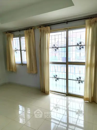 Bright room with large windows and elegant curtains, perfect for natural light lovers.