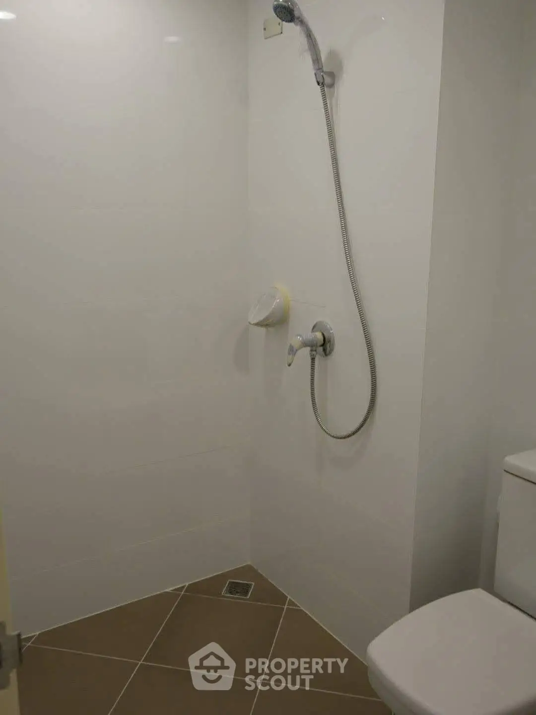 Minimalist bathroom with shower and toilet in a modern home.