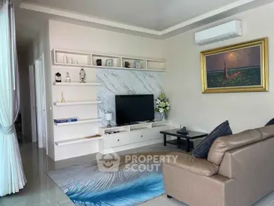 Stylish living room with modern decor, marble accent wall, and comfortable seating.