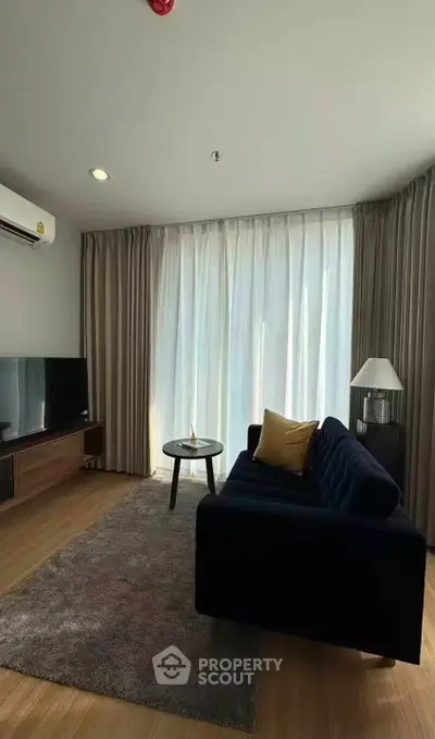 Stylish living room with modern furniture and large window for natural light