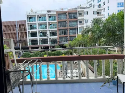 Spacious balcony with pool view in modern apartment complex