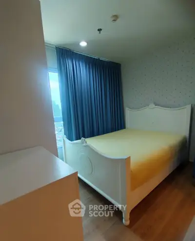 Cozy bedroom with elegant bed and large window offering city views, perfect for relaxation.