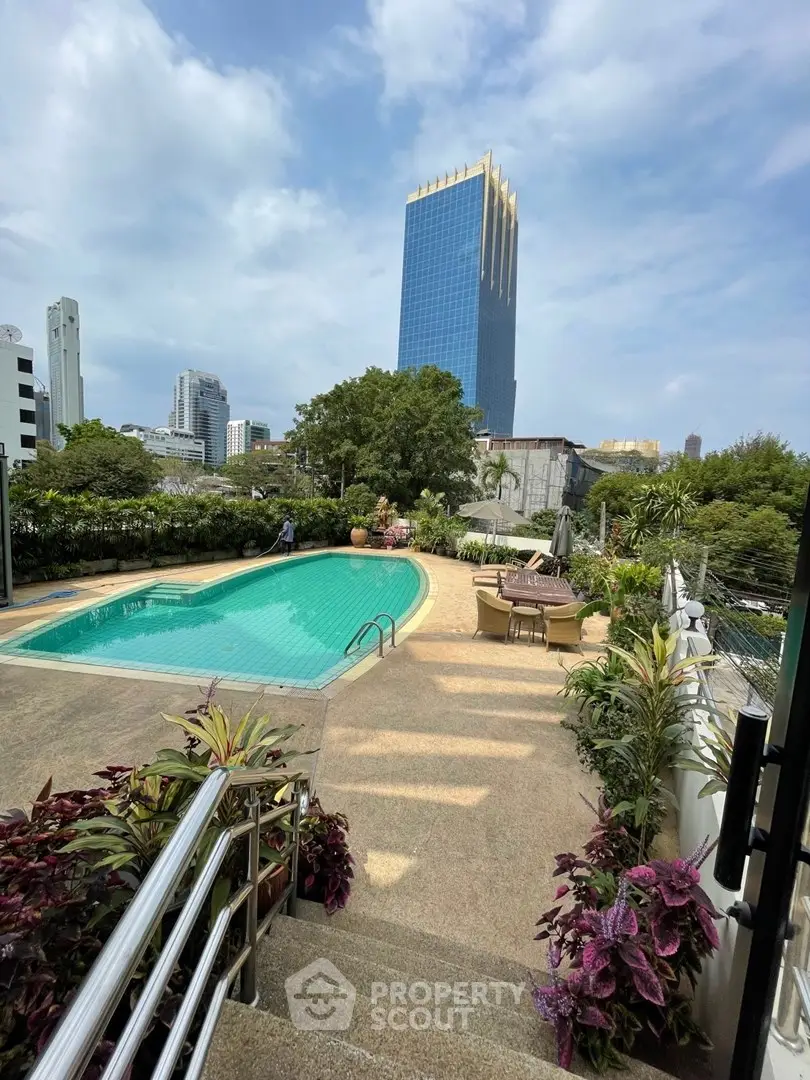 Luxurious urban poolside with stunning cityscape views and lush greenery, perfect for relaxation and leisure.