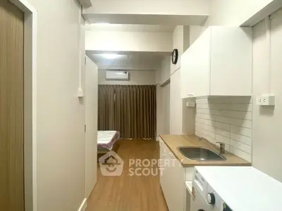 Modern studio apartment with compact kitchen and cozy sleeping area.