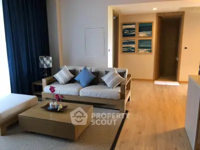 Modern living room with stylish decor and cozy seating area, featuring wooden flooring and elegant artwork.