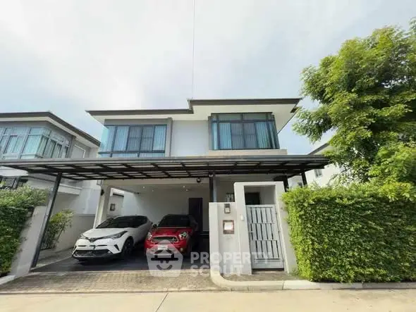 Modern two-story house with carport and lush greenery in a suburban neighborhood.