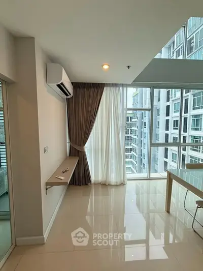 Modern living room with large windows and city view, featuring sleek air conditioning and elegant curtains.