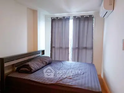 Cozy bedroom with modern air conditioning and natural light through large windows.