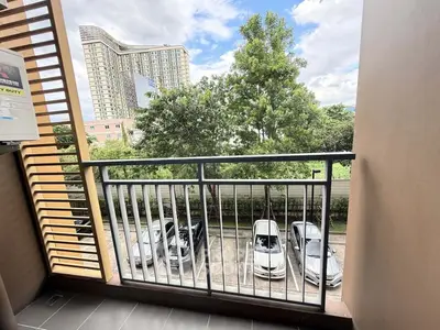 Charming balcony view overlooking lush greenery and modern architecture, perfect for urban living.