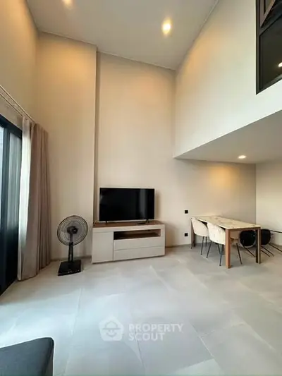 Spacious modern living room with high ceiling and elegant dining area