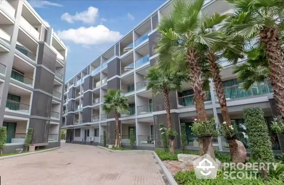 Modern apartment building with lush palm trees and spacious balconies