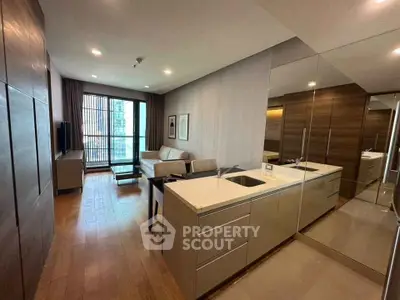 Modern living room with open kitchen and large windows in a stylish apartment.