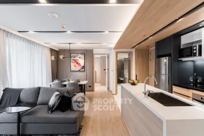 Modern open-layout living room and kitchen with sleek design and stylish decor.