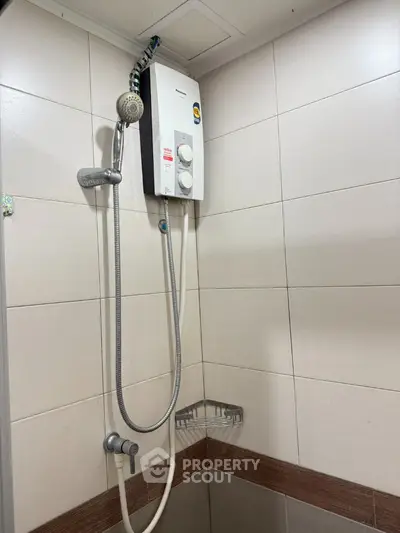 Compact bathroom corner with modern shower heater and tiled walls