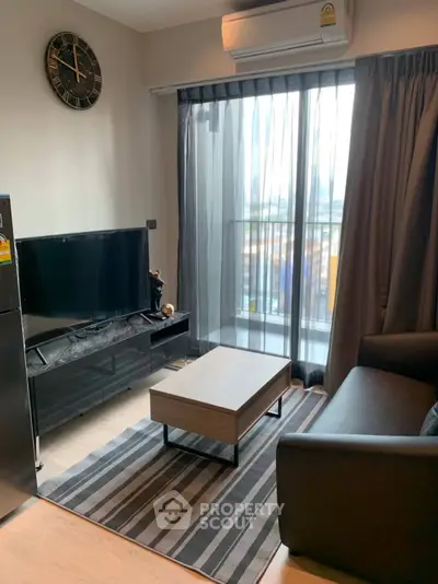 Modern living room with sleek furniture and large window offering city view.