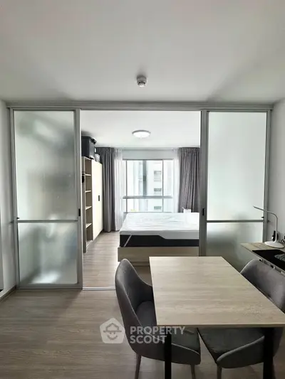 Modern studio apartment with sliding glass doors and compact dining area.