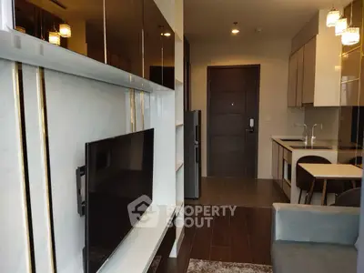 Modern apartment interior with sleek kitchen and cozy living area, featuring contemporary design and stylish lighting.