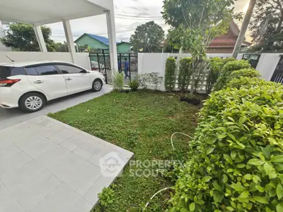 Charming residential garden with carport and lush greenery in a serene neighborhood.